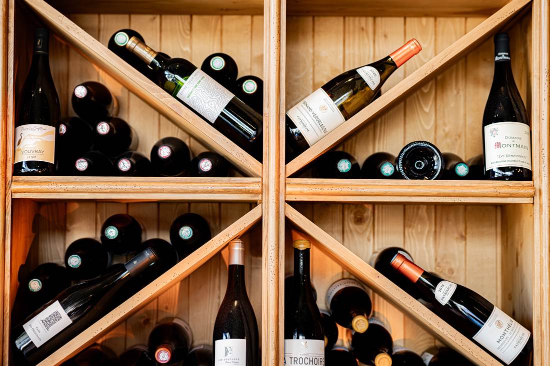 Bouteilles de vin rangées dans les casiers en bois de la cave